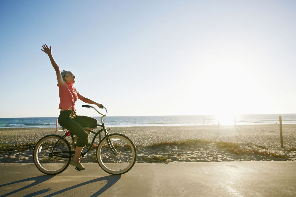 caucasian woman riding bicycle near beach