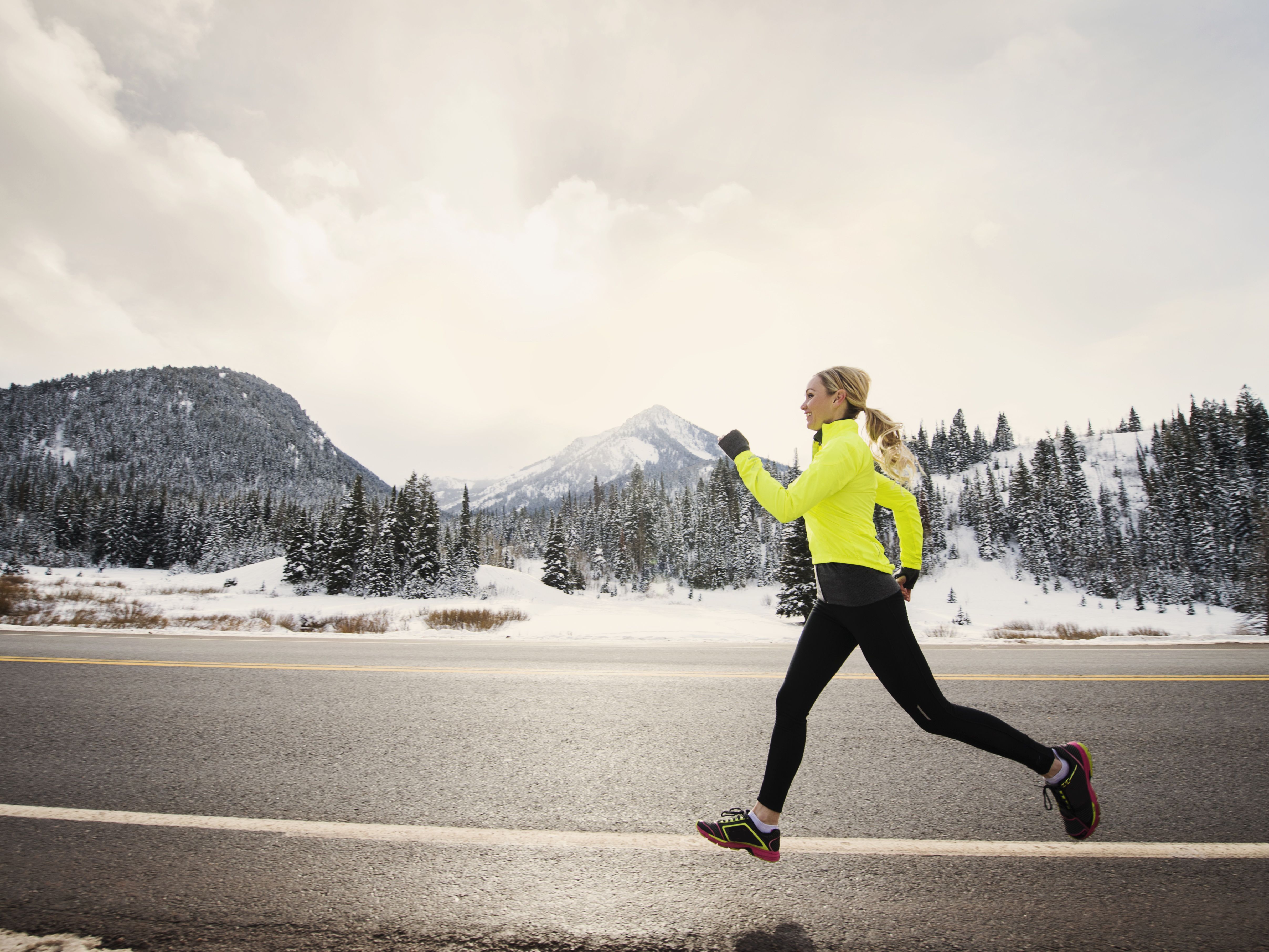 caucasian woman running on snowy road royalty free image 649658675
