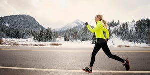 Caucasian woman running on snowy road