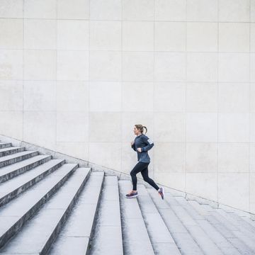 caucasian woman running up staircase