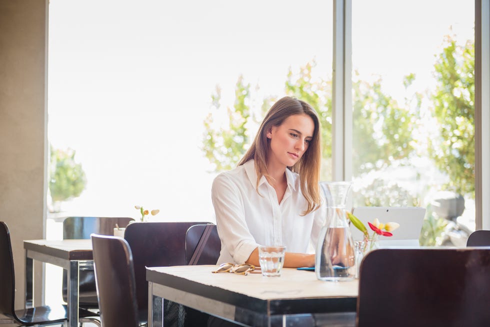 Caucasian woman using digital tablet in restaurant