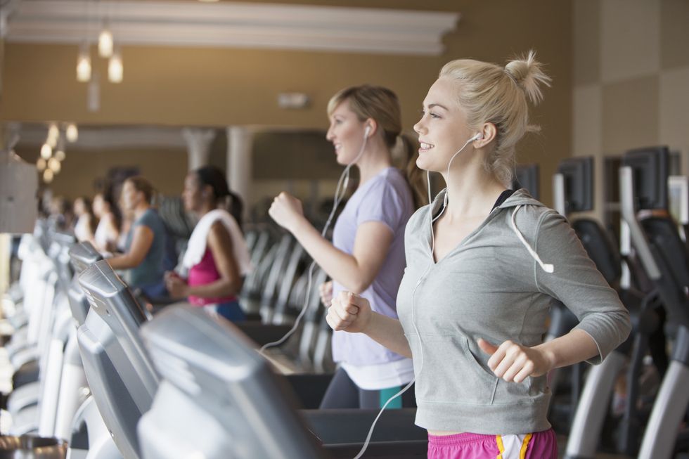 caucasian women exercising on treadmills in gym
