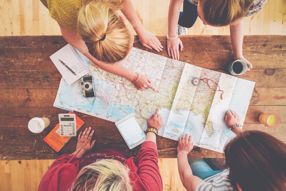 Caucasian women planning trip with map on wooden table