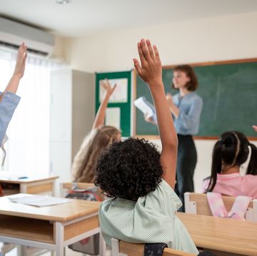 caucasian young woman teacher teaching student in classroom at school. attractive beautiful female instructor master explain and educate children with fun activity at preschool nursery kindergarten.