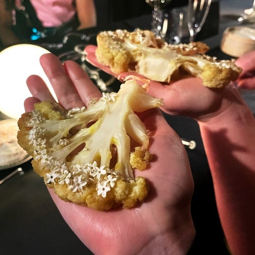 woman holding a large piece of cauliflower in her open palm