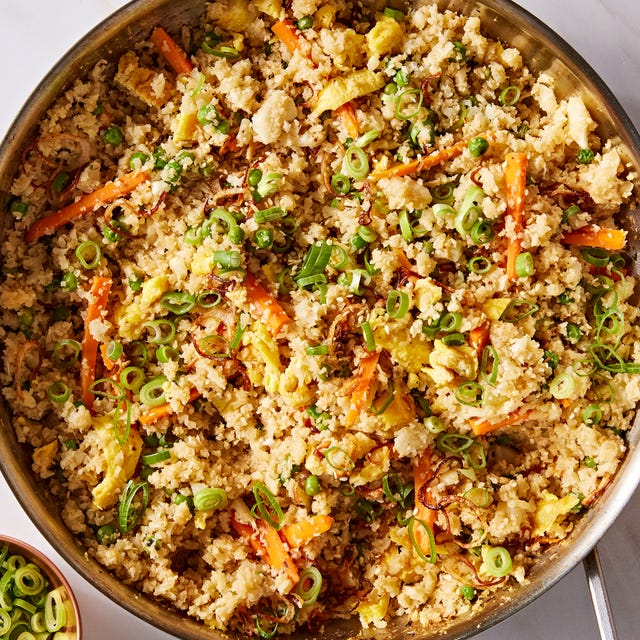 cauliflower fried rice with carrots, green onion, and eggs topped with sesame seeds