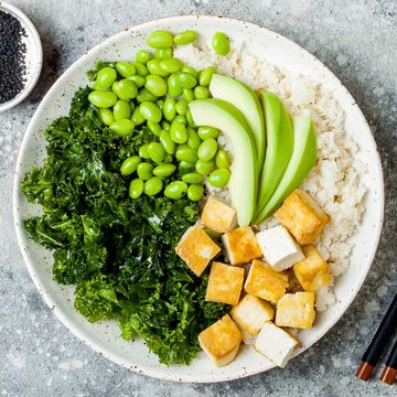 Cauliflower rice Buddha bowl with massaged kale, tofu, avocado and edamame beans. Vegan poke bowl