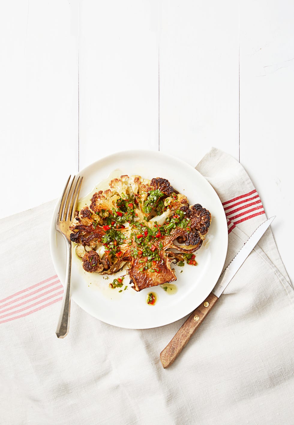 chimichurri cauliflower steaks on a striped tablecloth