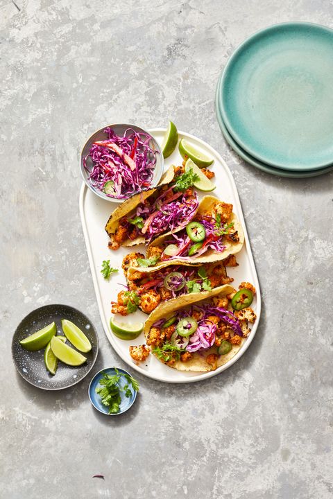 cauliflower tacos on a white platter with slaw