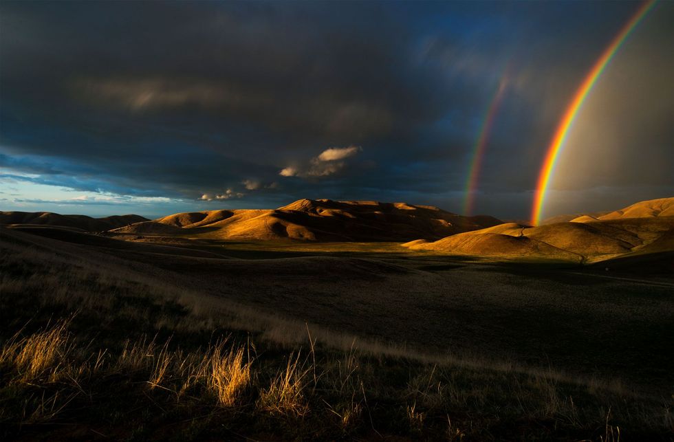 Tijdens een onweersbui in het late voorjaar vormen zich regenbogen boven de San Emigdio Mountains in Californi de ecologisch en geologisch diverse regio waar zich ook de Pinwheel Cave bevindt