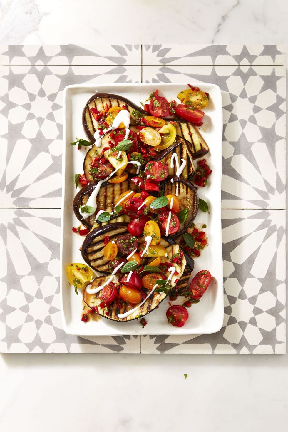 cayenne grilled eggplant with fresh tomato salad on a white plate
