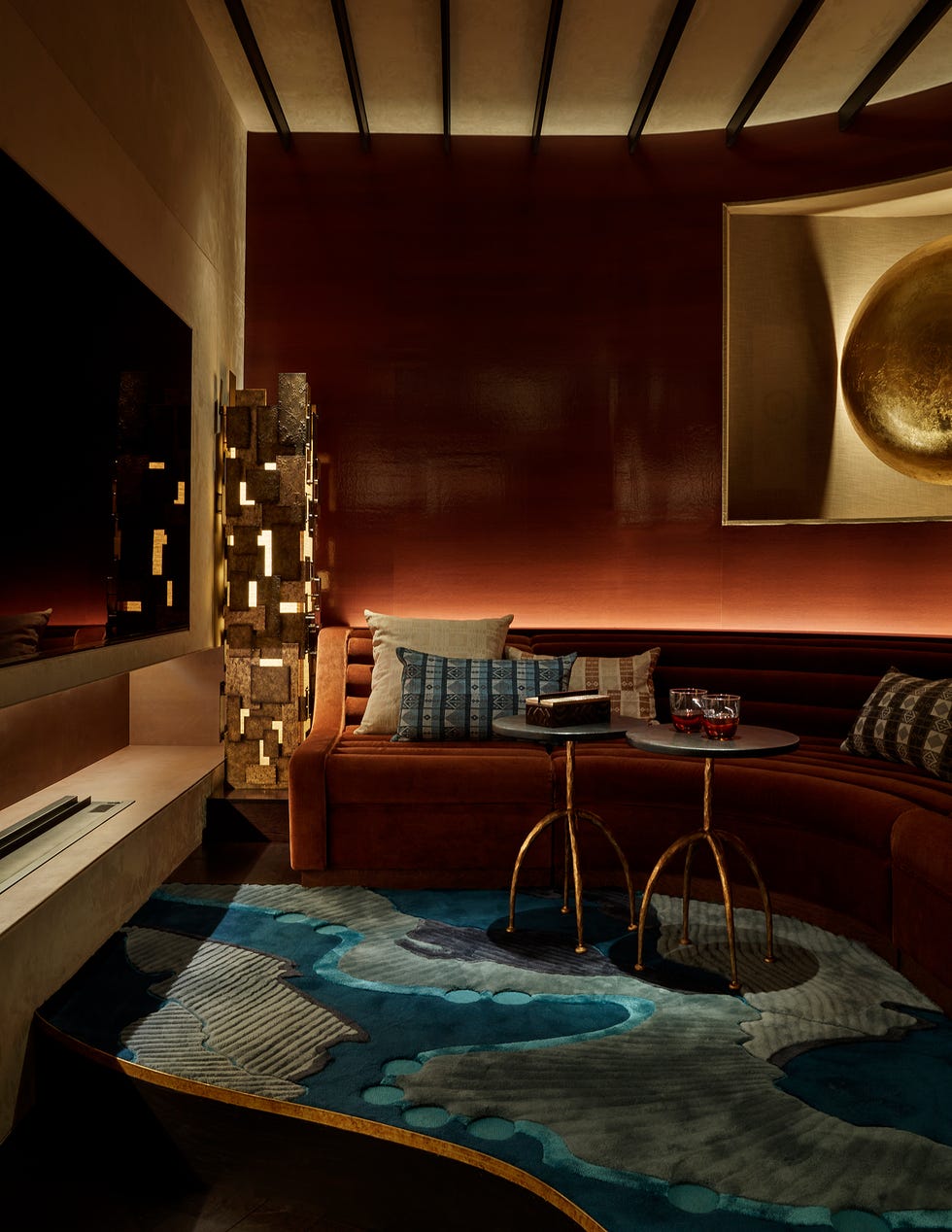 Stylish lounge area featuring a curved sofa, decorative pillows, and a unique rug.