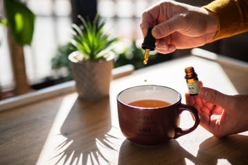 unrecognizable man using cbd oil in his tea