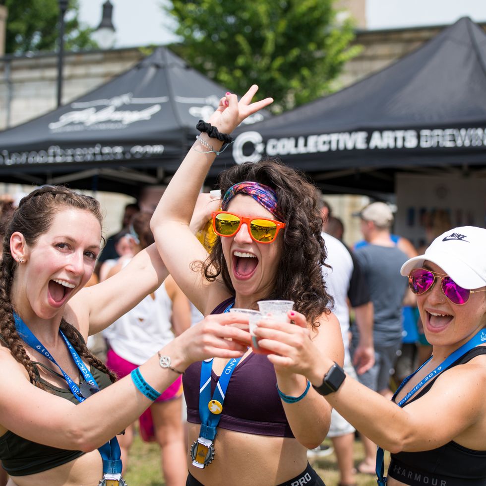 three runners cheers a beer after a craft brew race