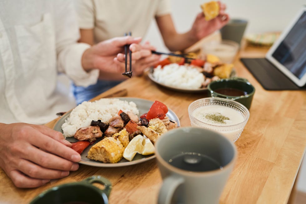 ccouple eating a one plate lunch with lots of vegetables