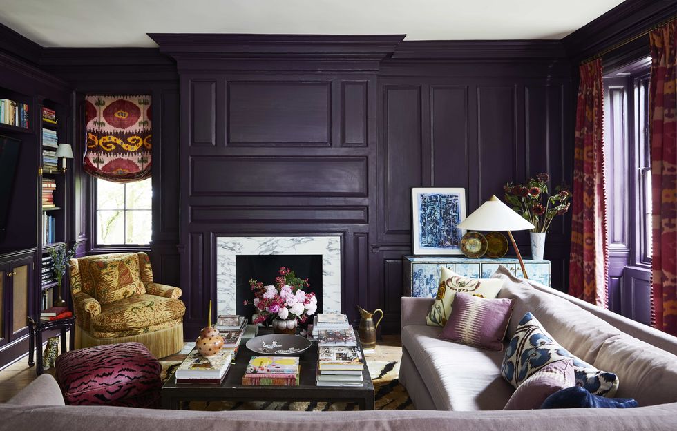a custom mohair sectional in a library surrounds a table and the walls are a dark eggplant hue