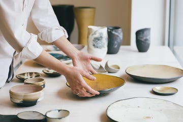 cearamic dishware at gallery, a handmade plate being put into a shop window