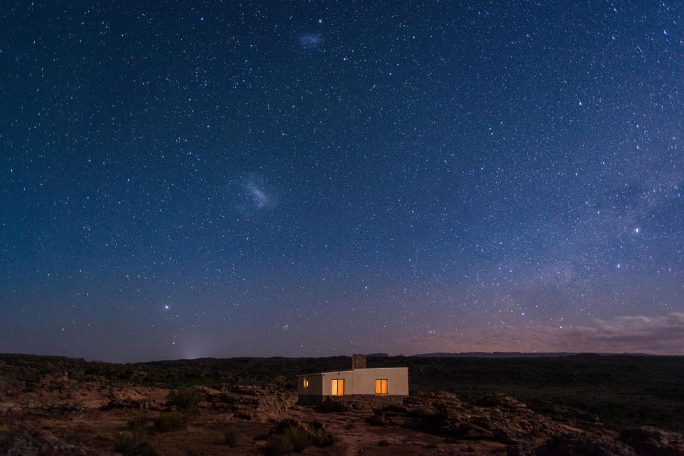 Een huis in de bergketen Cederberg oogt nietig onder een hemel vol sterren Het naburige Cederberg Astronomical Observatory is in de weekeinden geopend voor het publiek