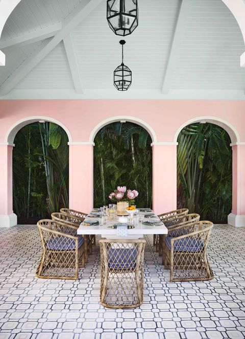 a white table with rattan chairs set for 8 on the terrace in naples, florida
