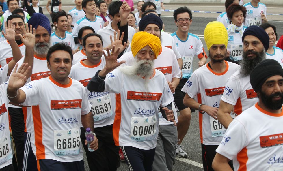 centenarian marathon runner fauja singh (centre), 101, originally from beas pind, in jalandhar, india but who now lives in london, runs on the eastern corridor expressway during 10 kilometer race, part of the annual hong kong marathon. 24feb13