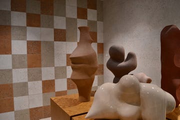ceramic sculptures in front of a tiled wall