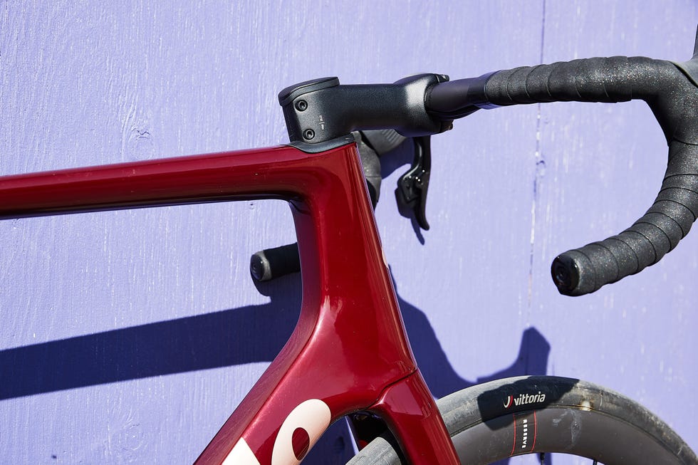Closeup of a bikes frame and handlebars against a purple background