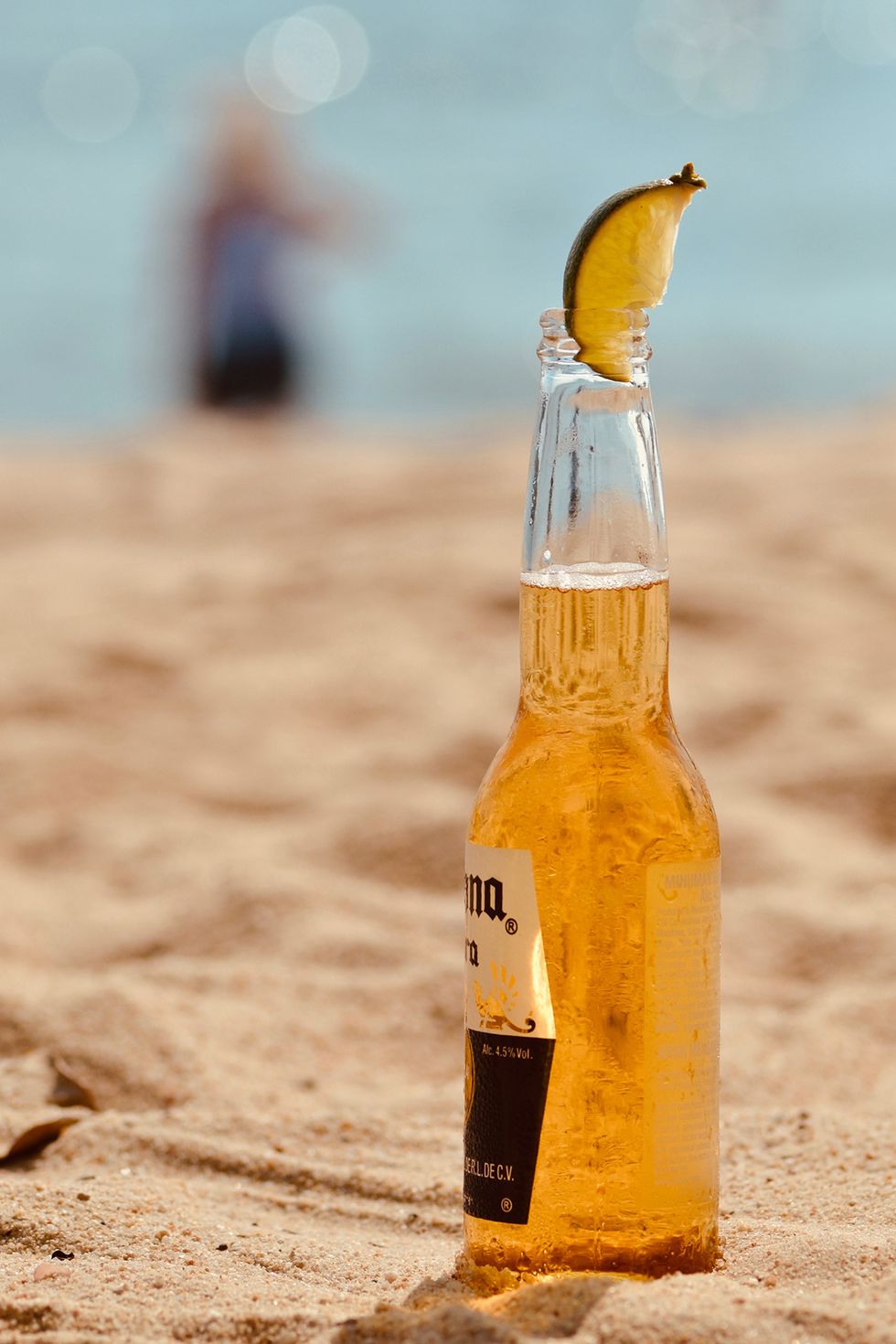 cerveza corona en la playa con un gajo de limón