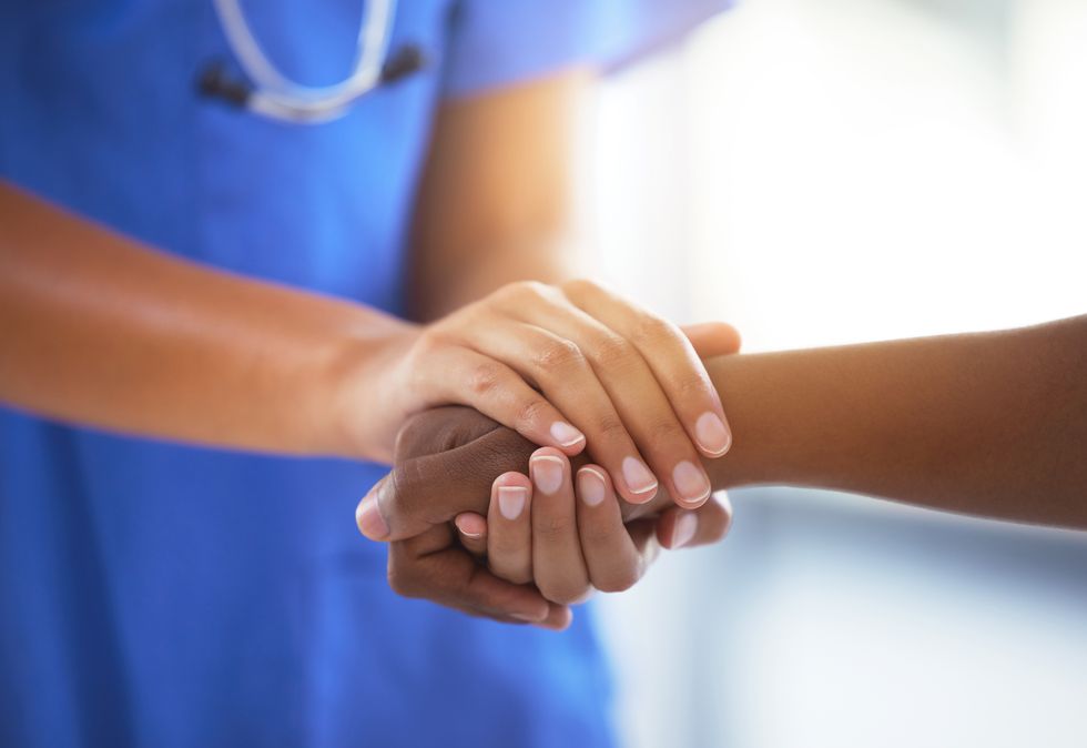 doctor holds hands with her patient