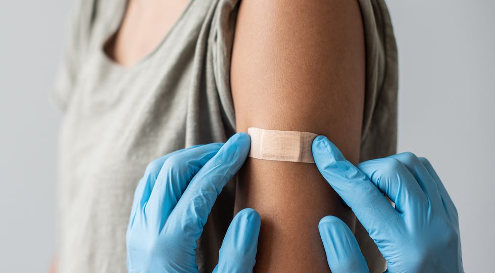doctor putting plaster at female hand after vaccination