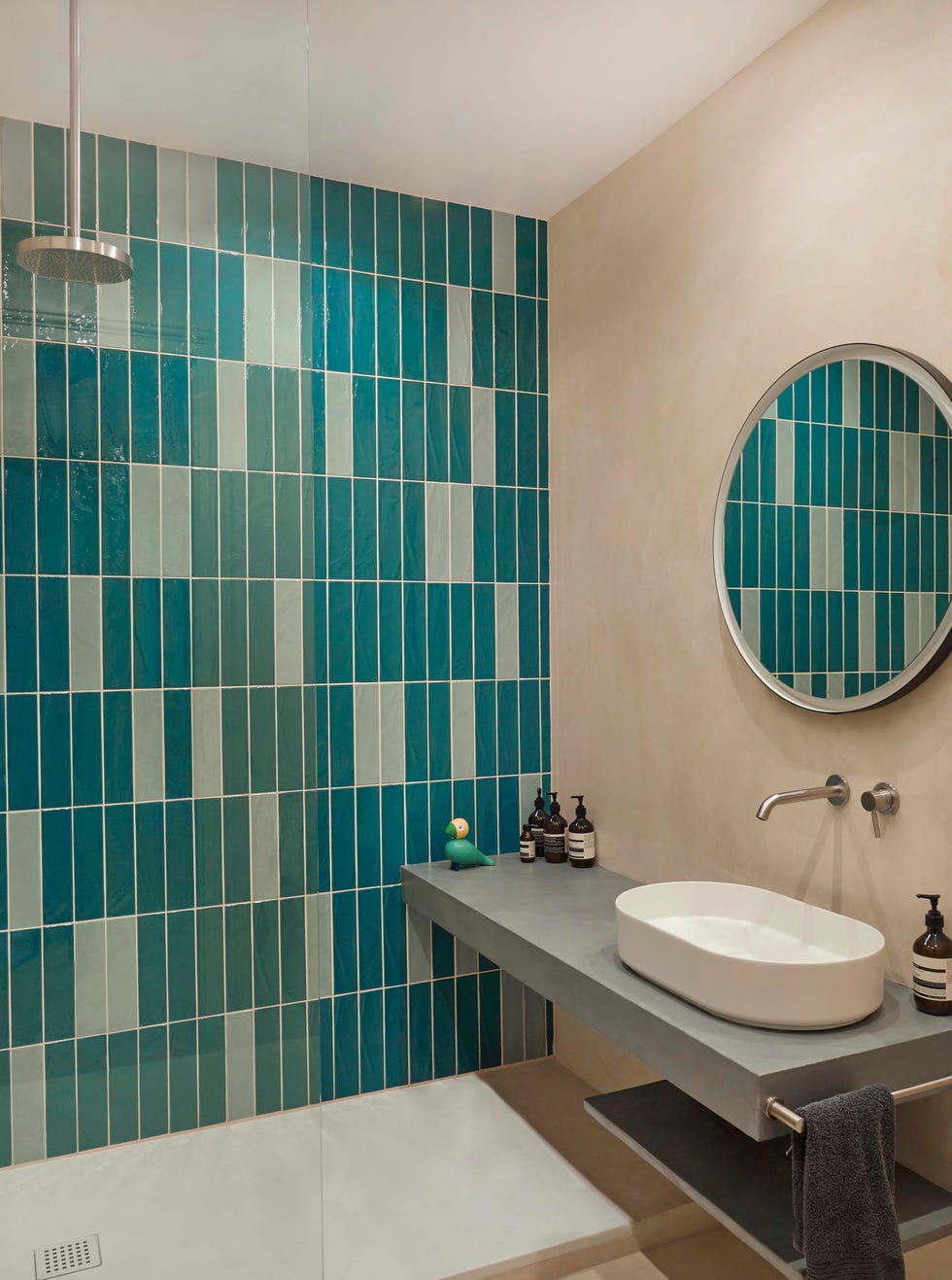 contemporary bathroom with teal wall tiles on one wall and rainforest shower head