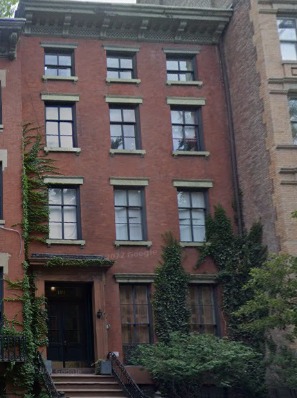 Four-story red brick building with green ivy and a central entrance.