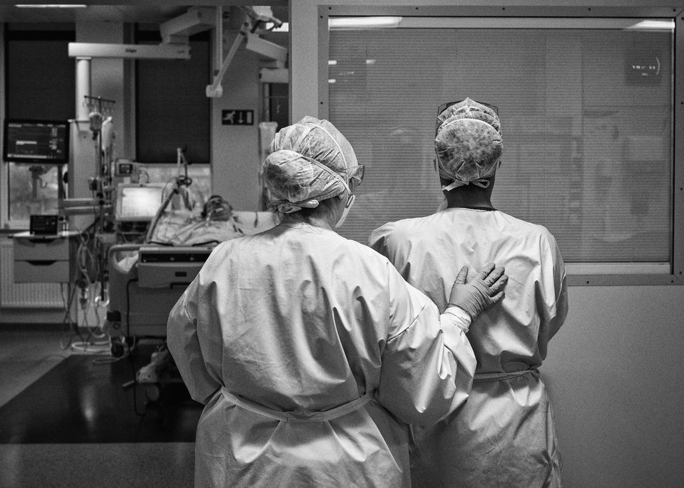 Een verpleegster op de ICafdeling van het Centre Hospitalier Universitaire Tivoli wordt getroost door een collega nadat een patint door complicaties als gevolg van COVID19 is overleden
