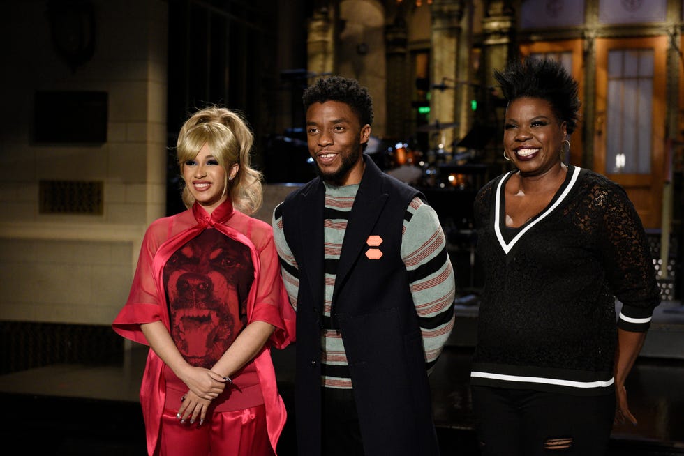 cardi b, chadwick boseman, and leslie jones stand on a stage and smile