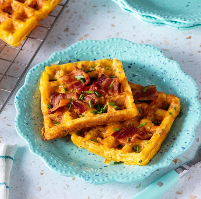 chaffles on blue plate with chaffles in back on cooling rack