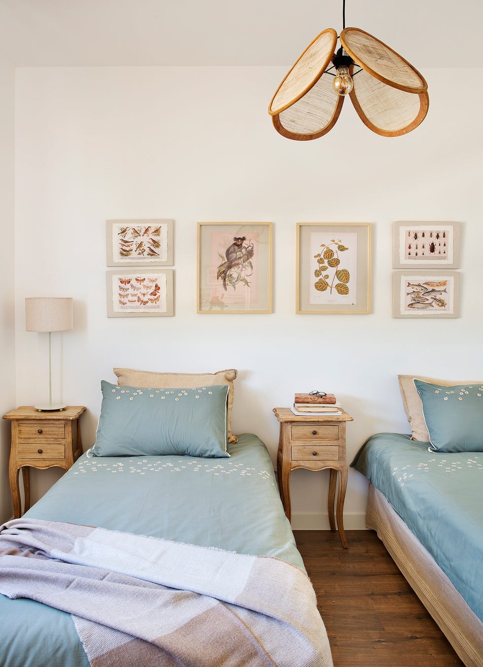 dormitorio infantil con dos camas y dos mesitas de noche de madera