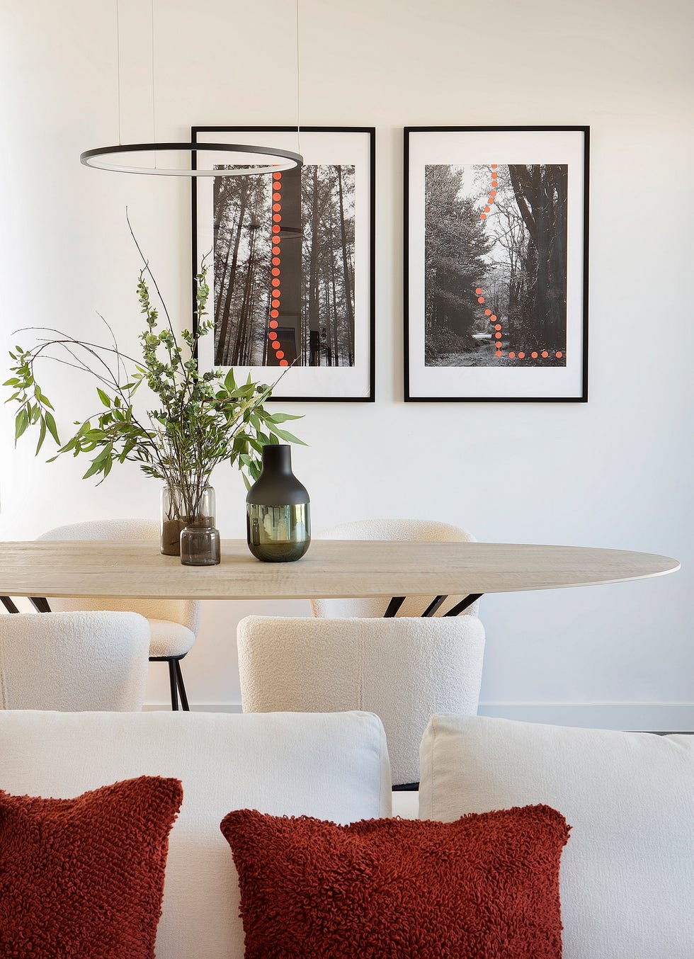 mesa de comedor ovalada con sobre de madera y patas de metal con sillas de rizo blanco