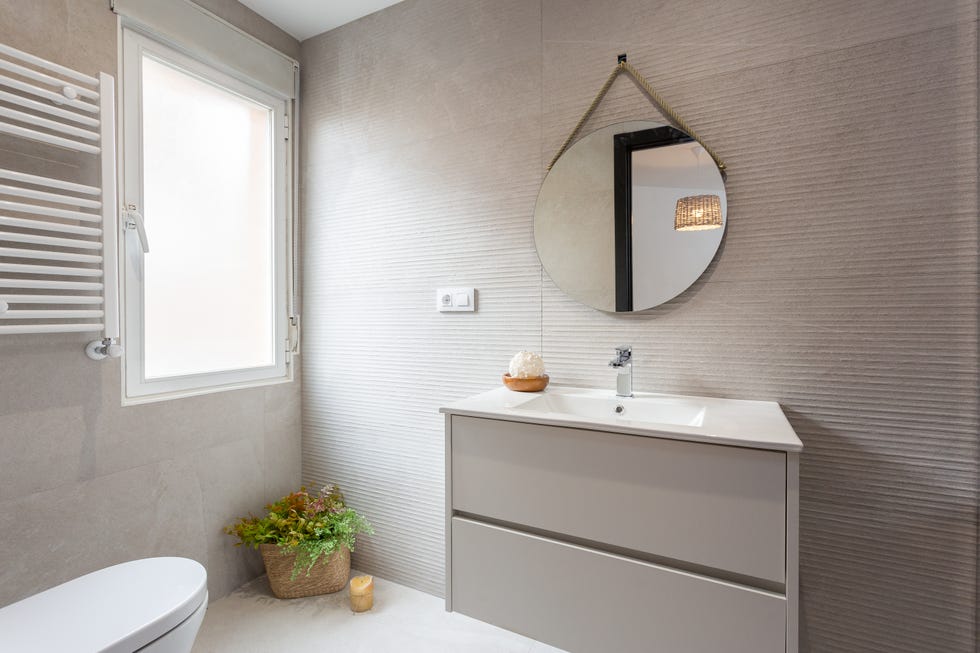 baño moderno decorado en gris con paredes de cemento
