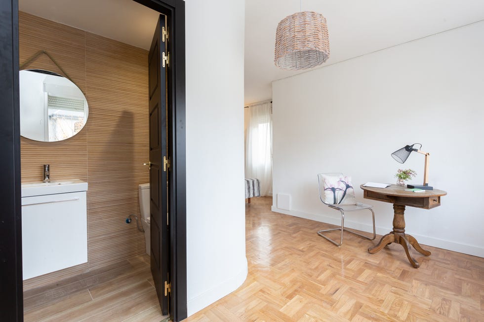 dormitorio con baño en suite y escritorio de madera vintage