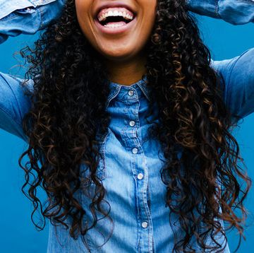 woman with long curly hair in chambray shirt