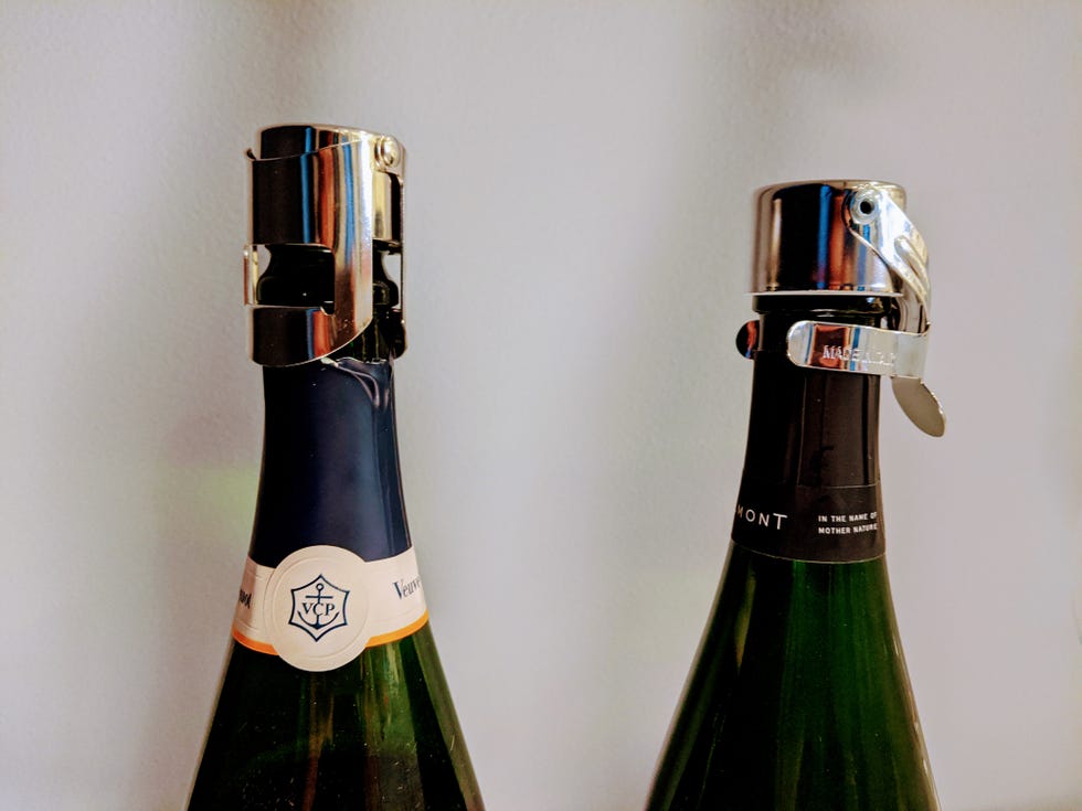 two champagne bottles with champagne stoppers secured on top