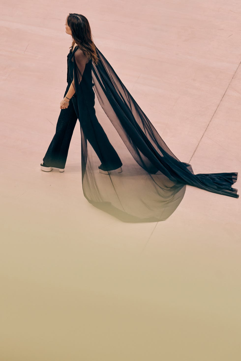 riley keough walking with a cape dragging behind her