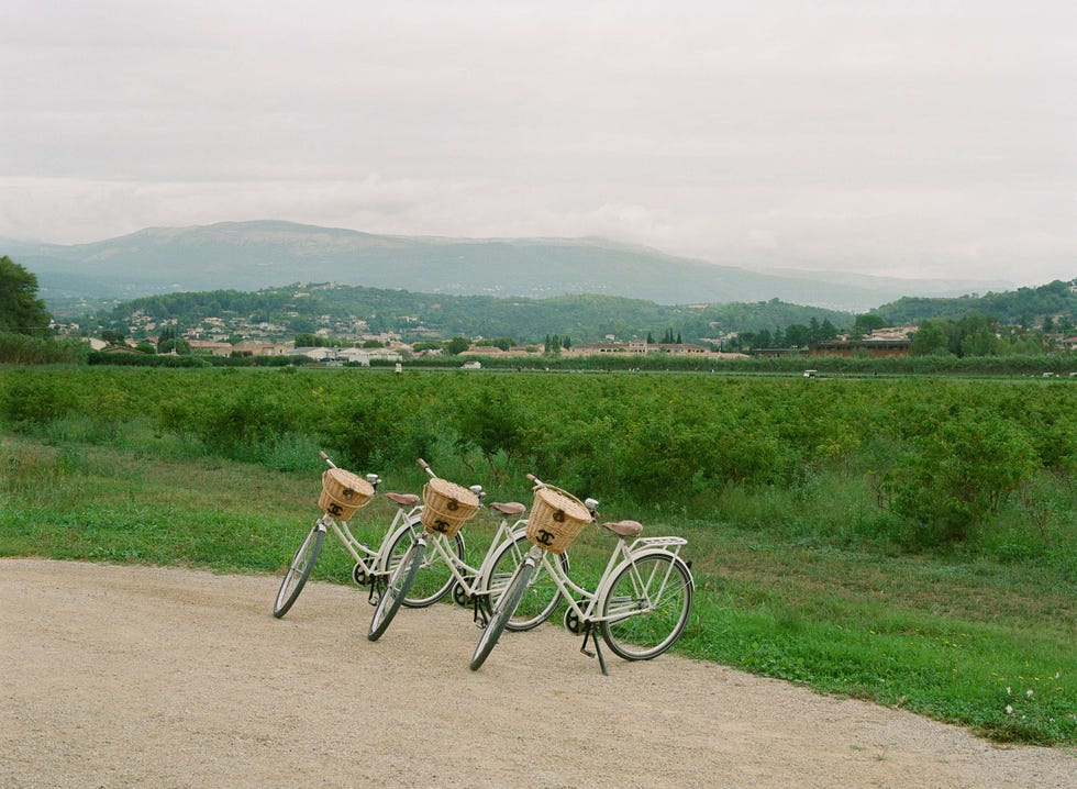 Group of bicycles parked on a dirt road with fields and hills in the background