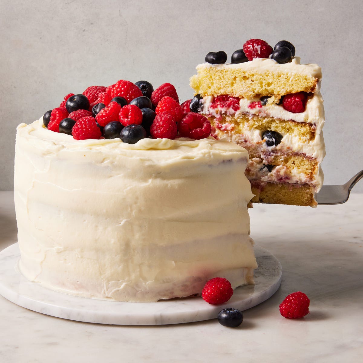 chantilly cake topped with raspberries and blueberries