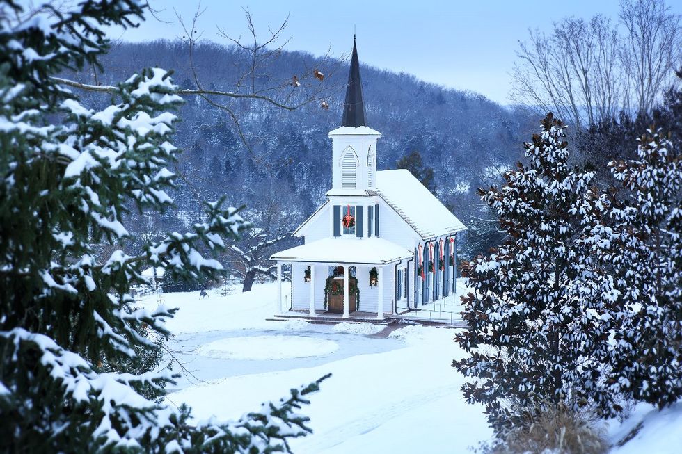 a white building with a steeple surrounded by snow