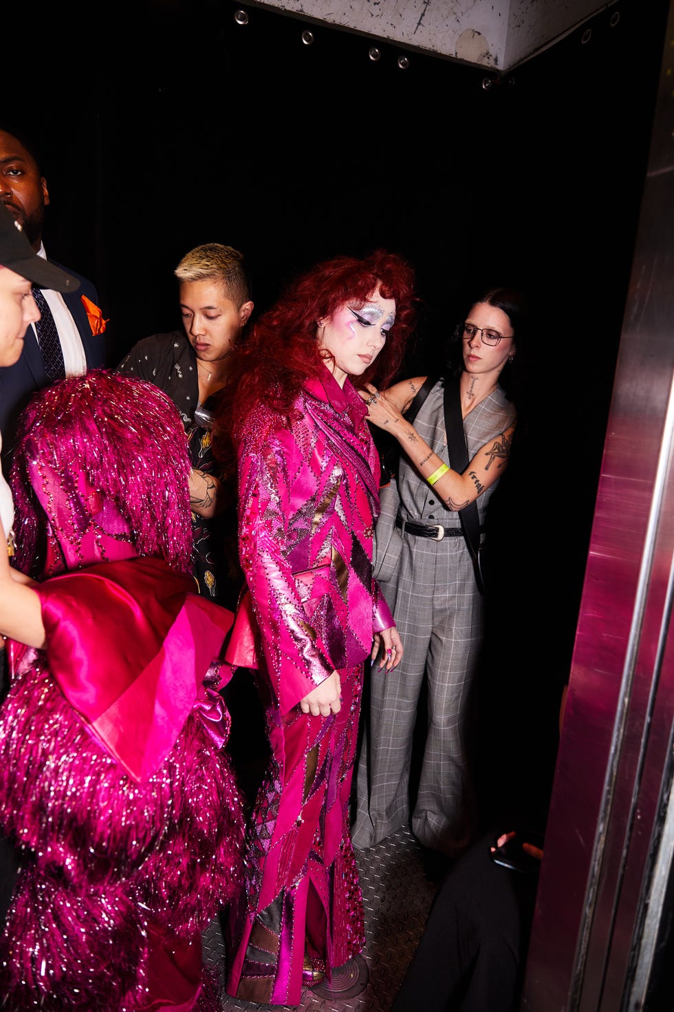 a group of individuals in vibrant outfits preparing backstage