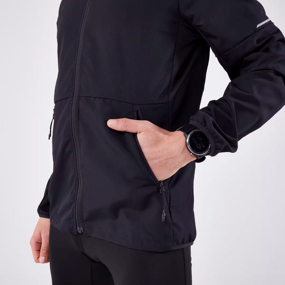 un corredor vistiendo la chaqueta cortavientos kiprun run 100 de decathlon para hombre en color negro