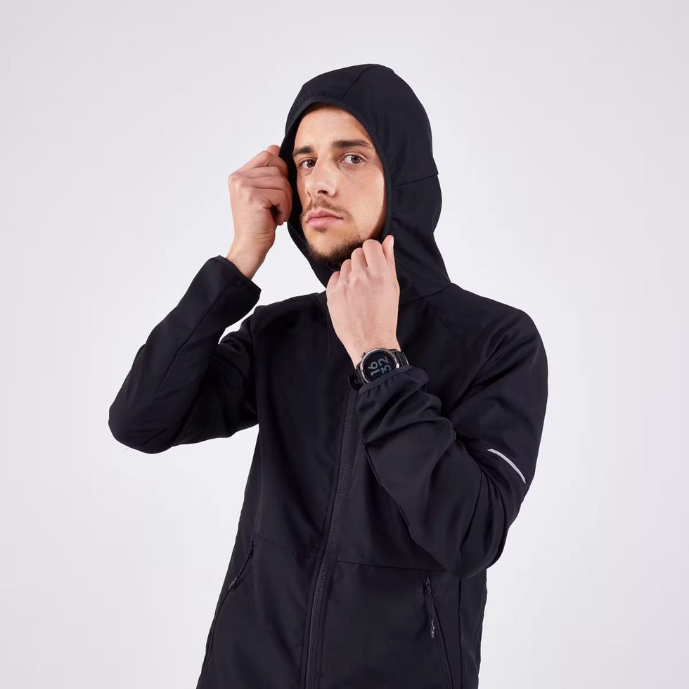 un corredor vistiendo la chaqueta cortavientos kiprun run 100 de decathlon para hombre en color negro