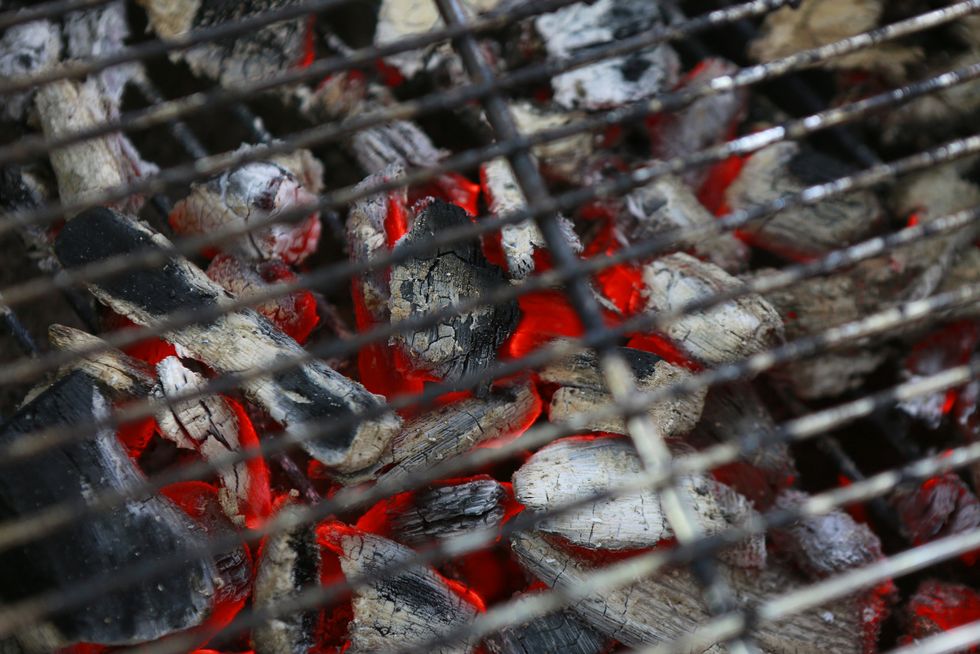charcoal burning under a grill at a barbeque