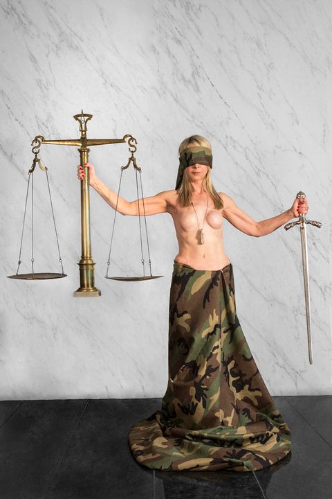 donna kaufman in a camo skirt and holding a sword with a camo blindfold