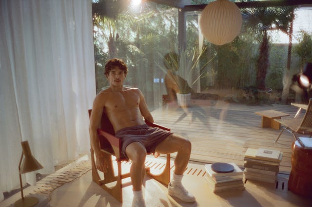 person seated in a relaxed position in a sunlit indoor space